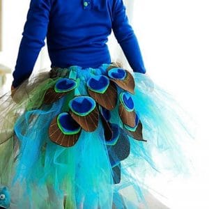 diy peacock tutu costume - green and turquoise tulle with felt peacock colored shapes sewn on back of tutu. Girl wearing tutu is wearing a peacock blue long sleeve shirt