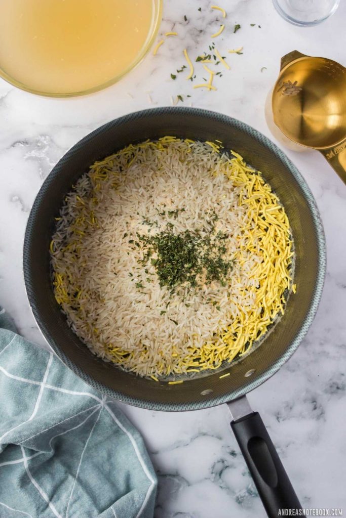 sauteed pasta with rice and spices on top in a black saucepan