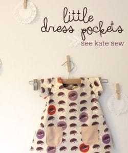 white wall with tiny dress hanging on a hanger attached to wall. Dress is white with purple patter and light pink front pockets. Text on image says "little dress pockets see kate sew"