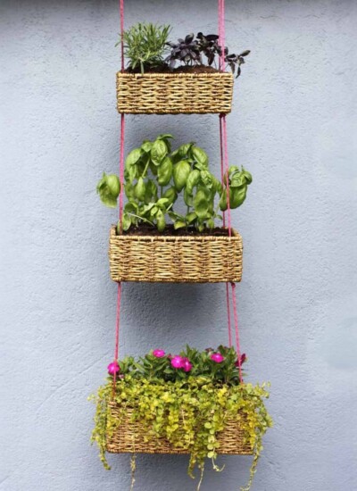 3 tiered hanging baskets with rectangular baskets and pink string.