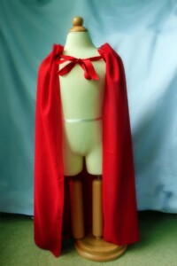 Red no sew DIY cape hanging on a manequin.