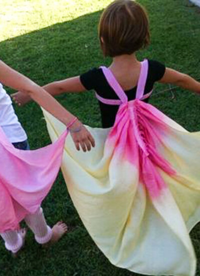 Two little girls wearing DIY silk butterfly wings that are dyed pink, yellow and putple.