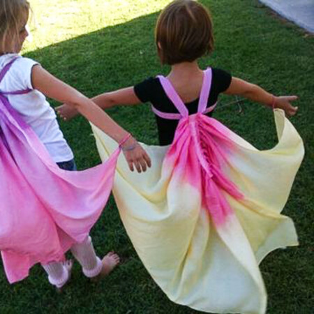 Two little girls wearing DIY silk butterfly wings that are dyed pink, yellow and putple.