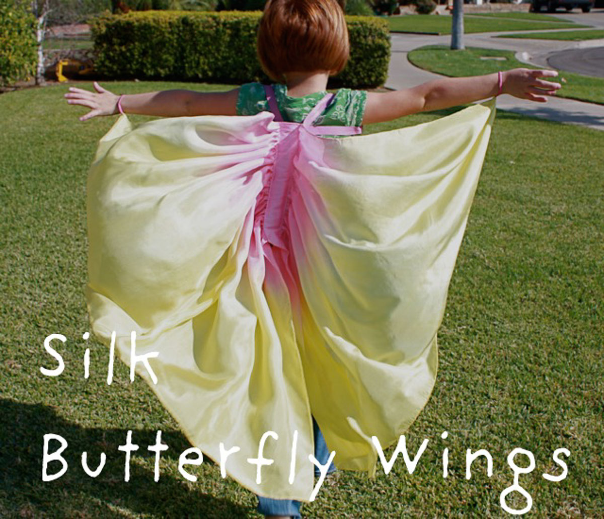 Girl wearing pink and yellow homemade DIY silk butterfly wings.