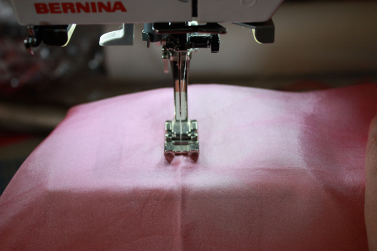 Sewing machine sewing stitches on fabric.