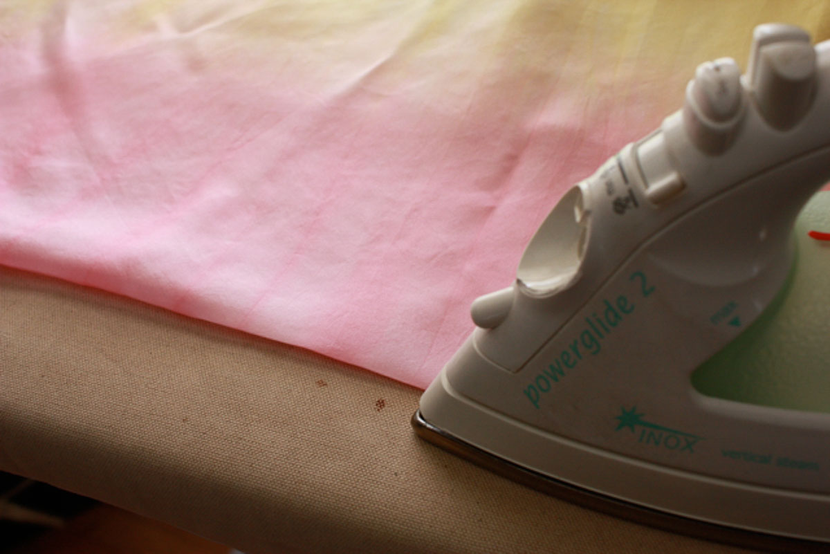 Iron ironing pink silk scarf.