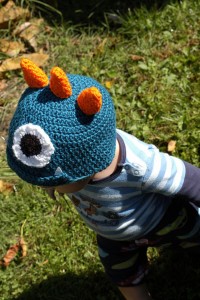 Boy wearing spiked crocheted monster hat.