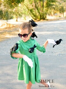 Girl in a green dress with fake black birds on her for a Hitchcock "The Birds" costume.