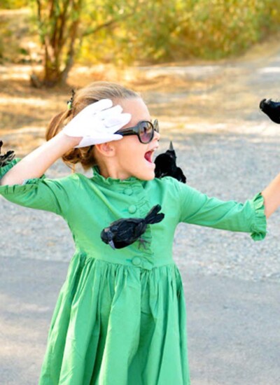 Young girl wearing a DIY Melanie Daniels The Birds costume with fake birds on her.