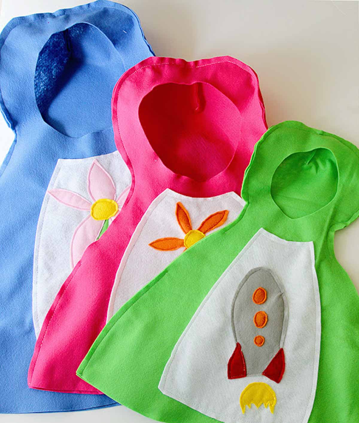 Blue, pink and green DIY nesting doll costumes laying flat on top of each other.