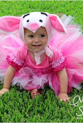 Little girl wearing tutu and piglet hat.