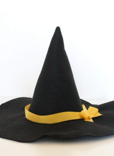 DIY black felt witch hat with a yellow ribbon on the brim.