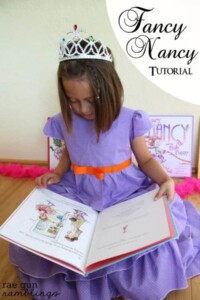 GIrl in purple DIY fancy nancy costume reading the Fancy Nancy book.