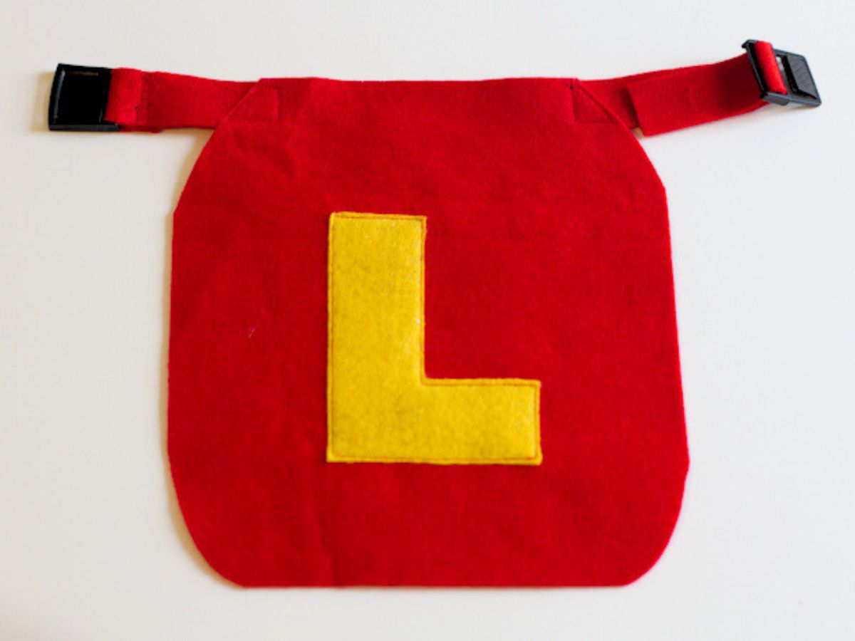 Red felt DIY superhero cape for dogs with buckle clasp and a yellow "L".