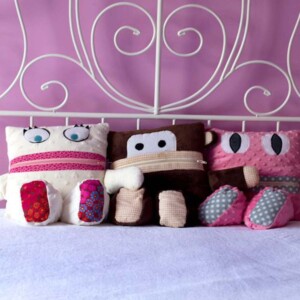 Three pajama keeper pillows on a bed.