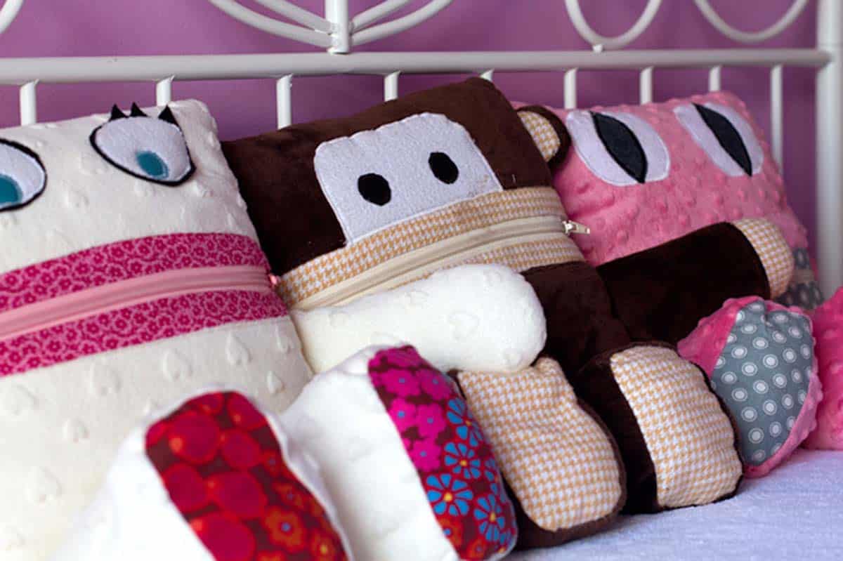 Close up of three DIY pajama eater monster pillows with zipper mouths.