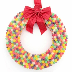 Colorful DIY gumdrop wreath with a red bow on top.