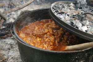 Slow cook chili over a campfire using a dutch oven