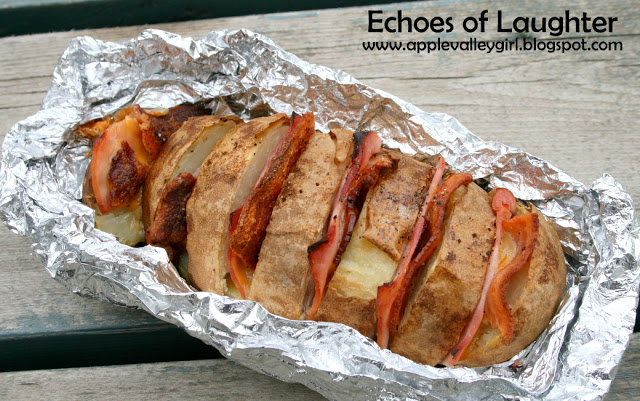 Load up a potato with cheese and ham, wrap in foil, and bake over your campfire!