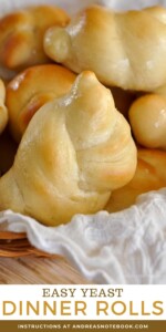 Knotted dinner rolls with a buttery top in a basket.