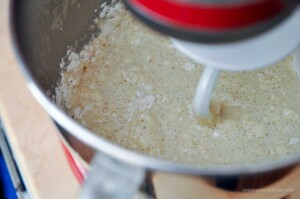 Flour added to KitchenAid mixing bowl with dough hook attachment.