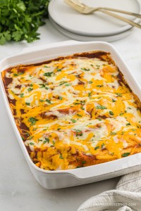 Homemade easy chicken enchiladas with red sauce in a casserole dish.