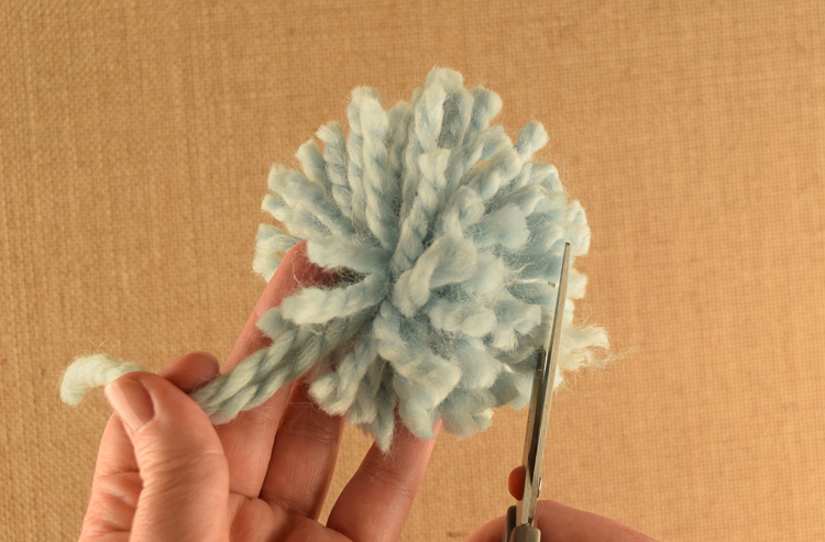 How to shape a pom pom by hand with scissors