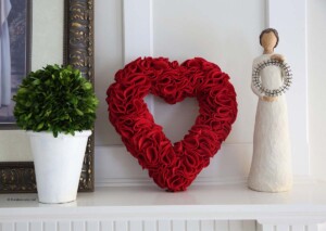 Red DIY felt heart wreath on a hearth.