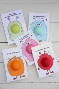 5 printed valentines with cartoon monsters and an EOS chapstick attached to the middle of the monster's tummy.