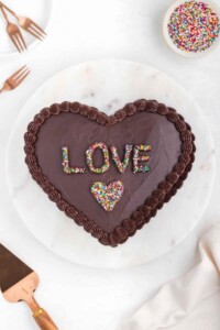 Chocolate heart shaped cake with the word "love" on top.