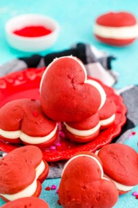 Heart shaped red whoopie pies in a pile.