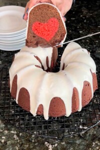 Round bundt cake with slice removed. Slice has a red heart inside it.