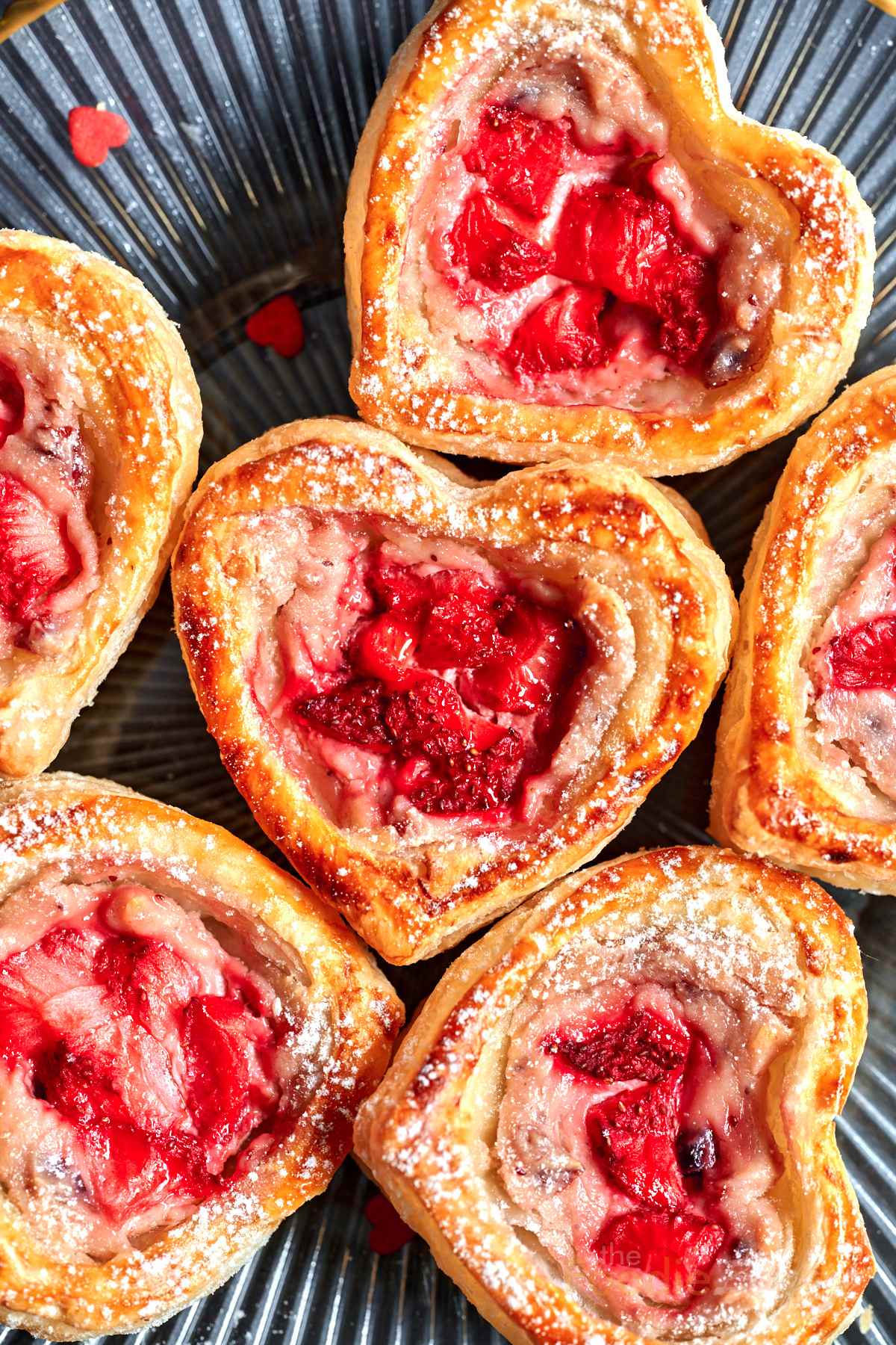 Heart shaped puff pastry with red strawberry and cream cheese filling.