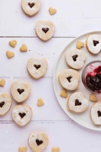 White cookies with a heart shaped red raspberry center.