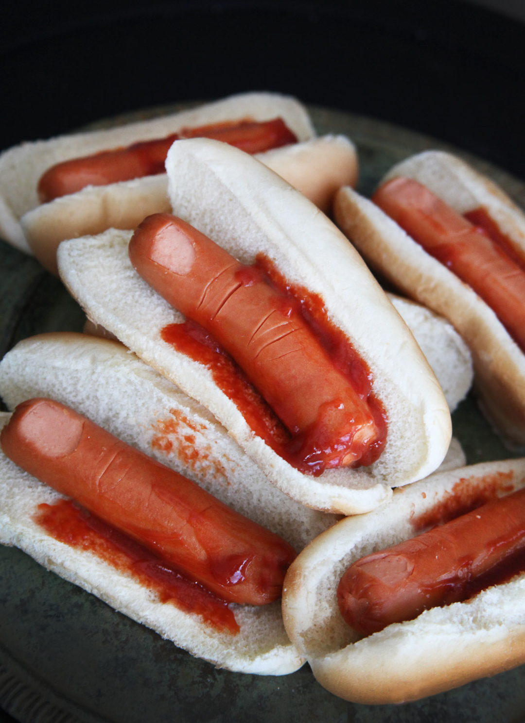 The scariest Halloween treat: bloody fingers are hotdogs in a bun with ketchup.