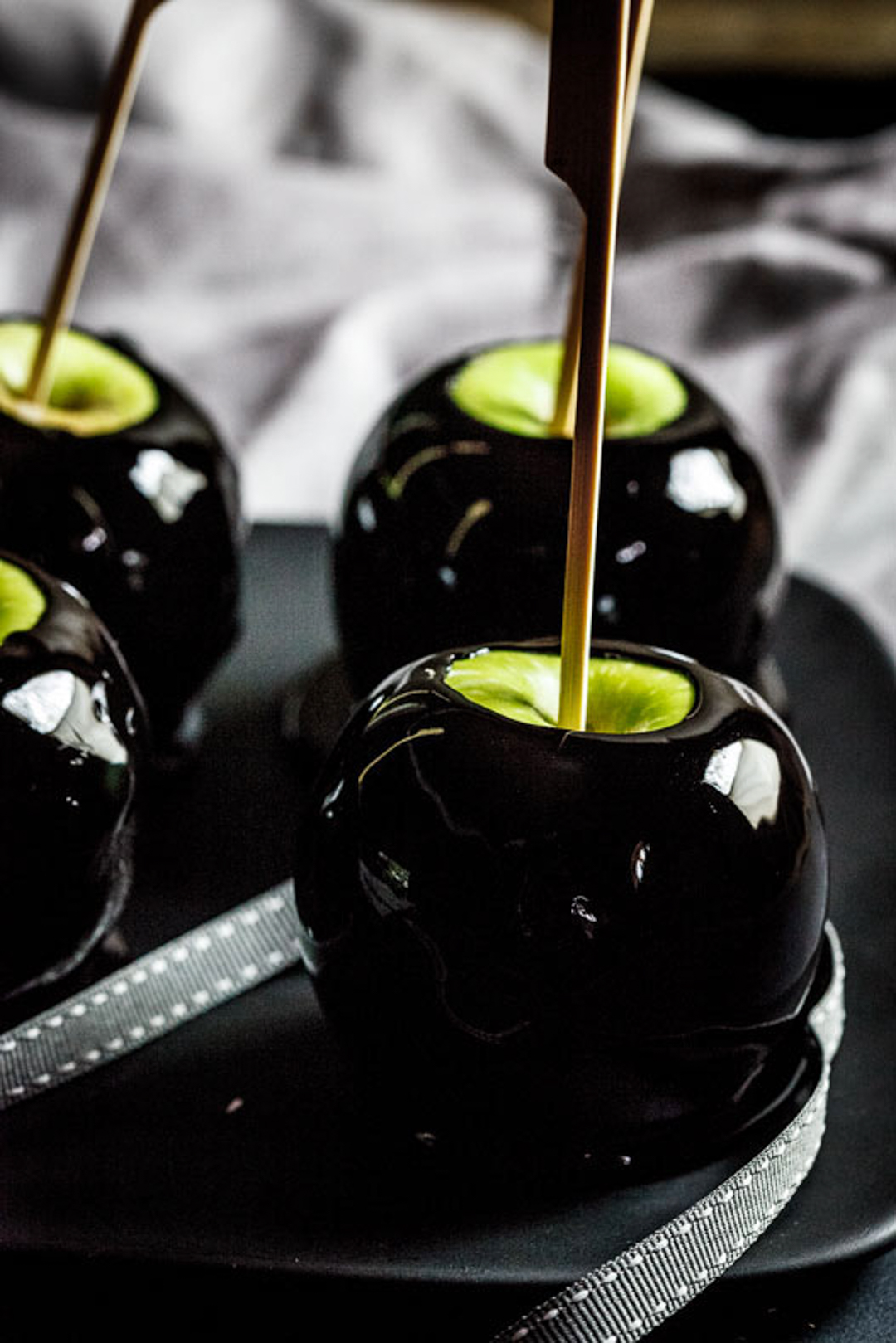 Black toffee apples with a stick in them.