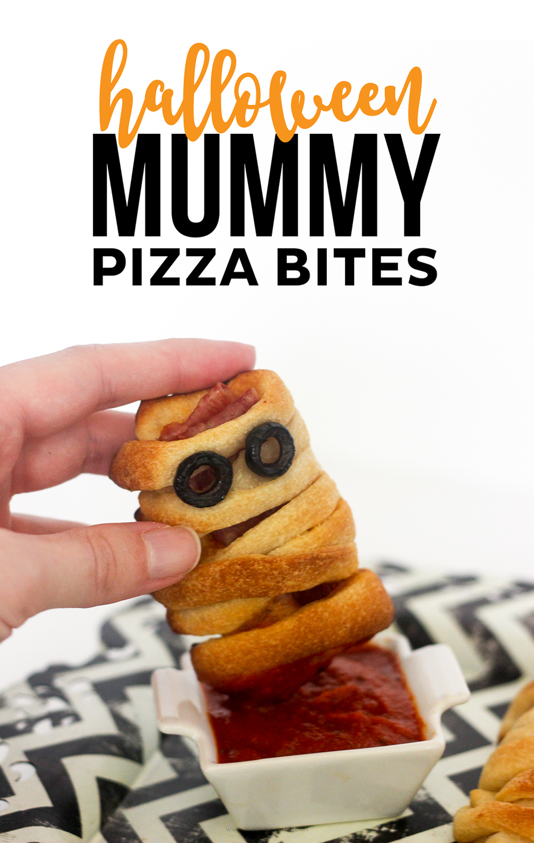 Scary Halloween treat of a mummy pizza bite dipped into sauce.