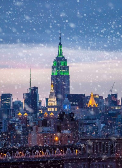 Snow coming down in New York City with the Empire State Building in background.
