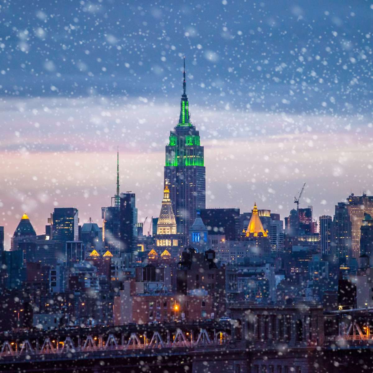 Snow coming down in New York City with the Empire State Building in background.