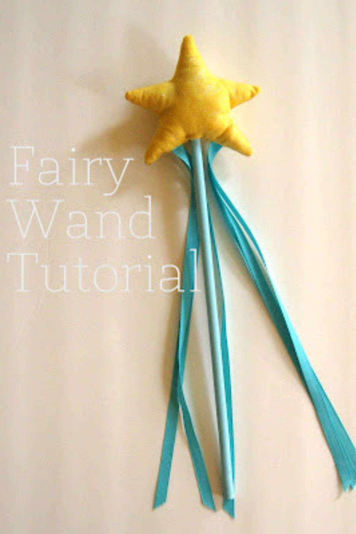 Star fairy wand with blue handle and ribbons and yellow star on top.