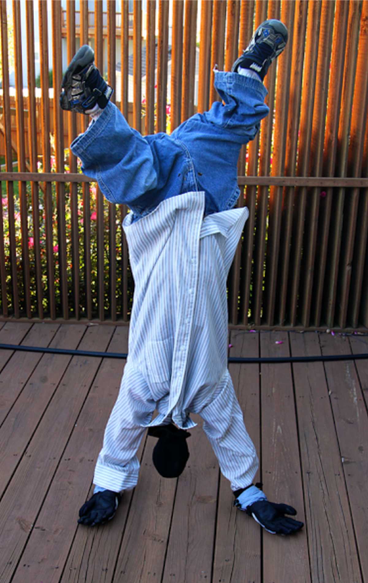 Upside down man costume with feet in the air and hands on the ground.
