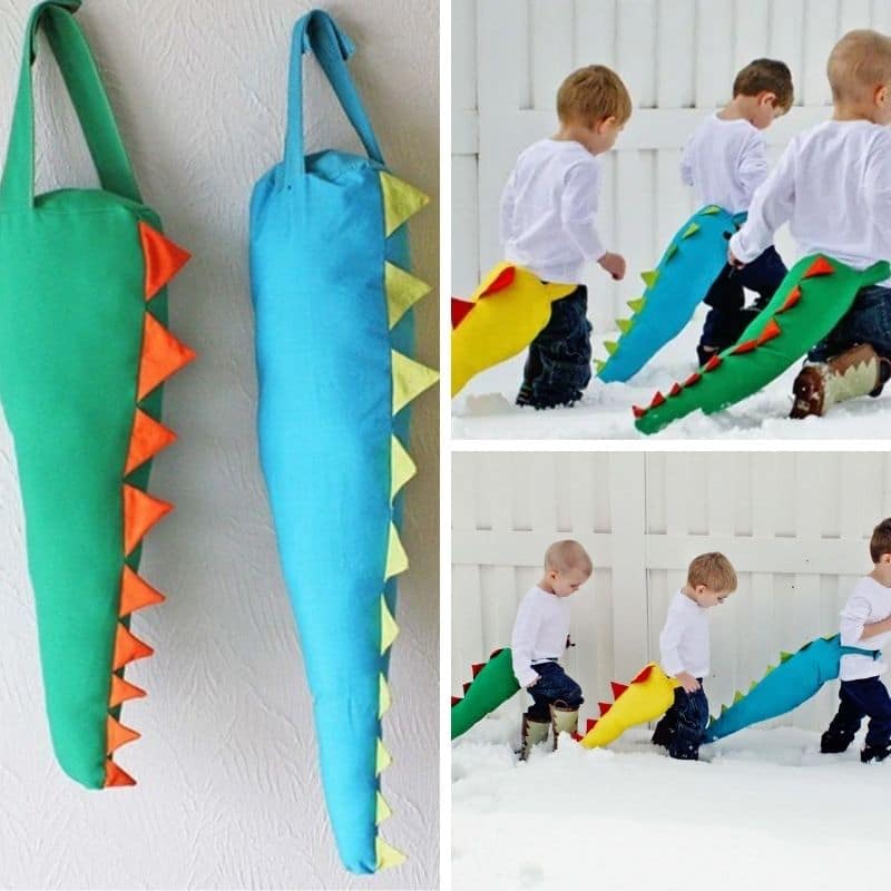 blue, green and yellow stuffed dinosaur tails worn by 3 little boys in snow