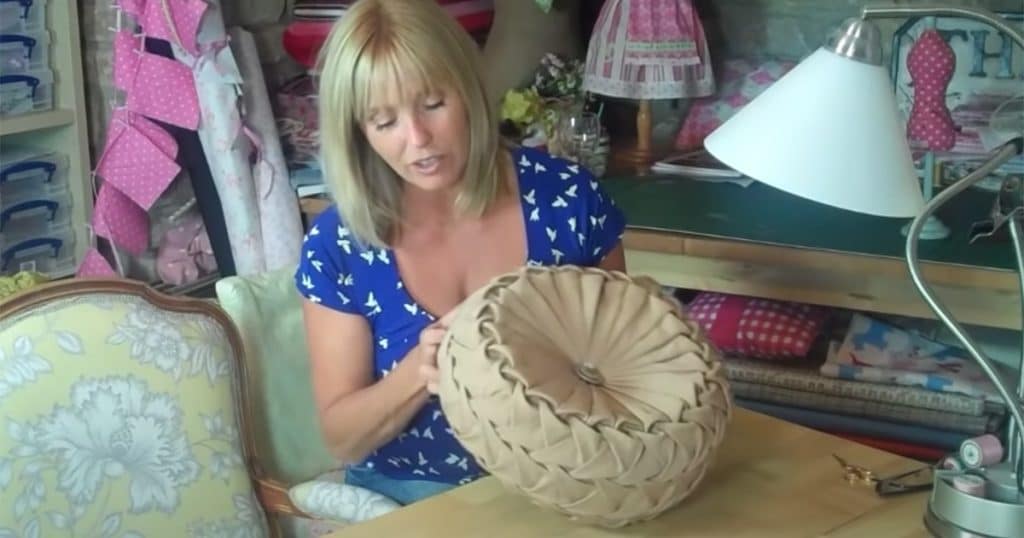 woman holds brown round pillow