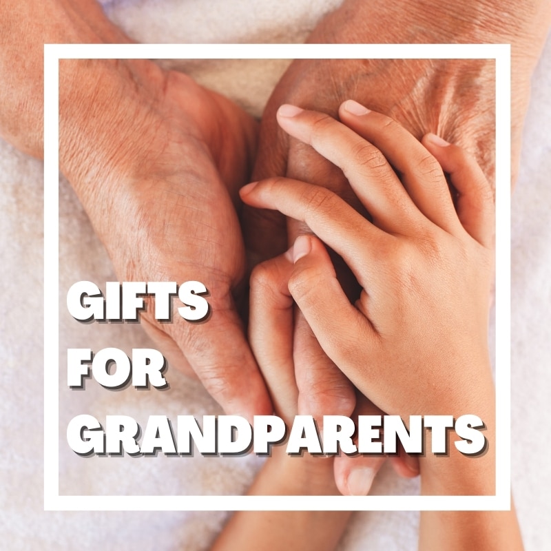 grandparents holding child hands