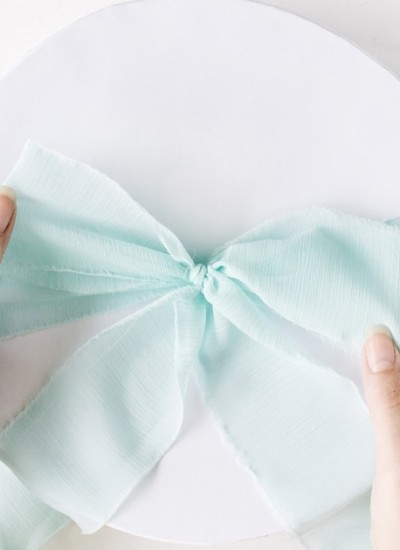 light blue bow tied on white round gift