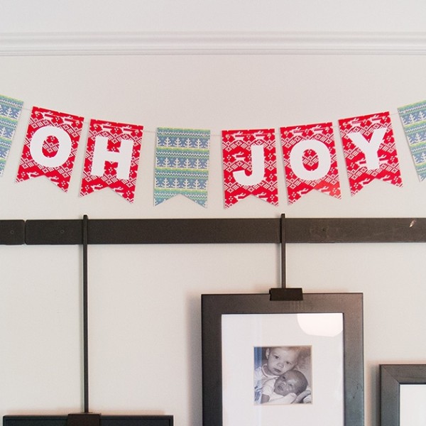 "oh joy" christmas bunting on wall above photo frames