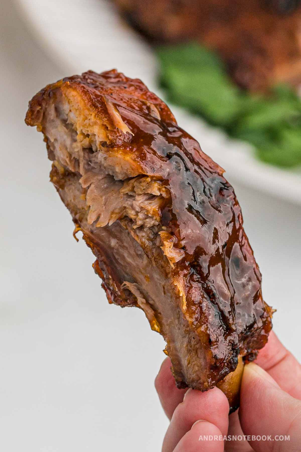 Hand holding one bbq rib.