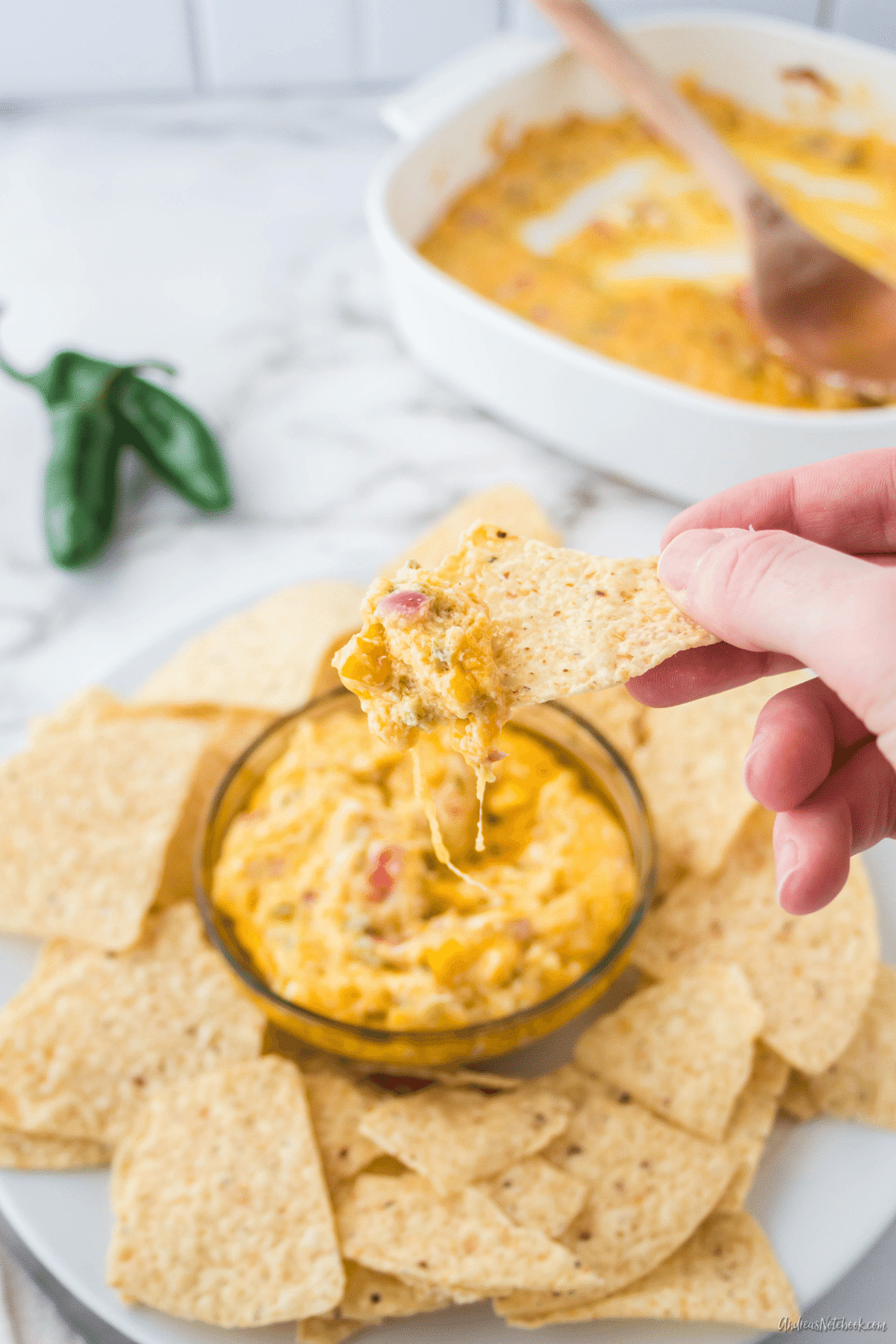 chip dipped into cheesy jalapeño dip