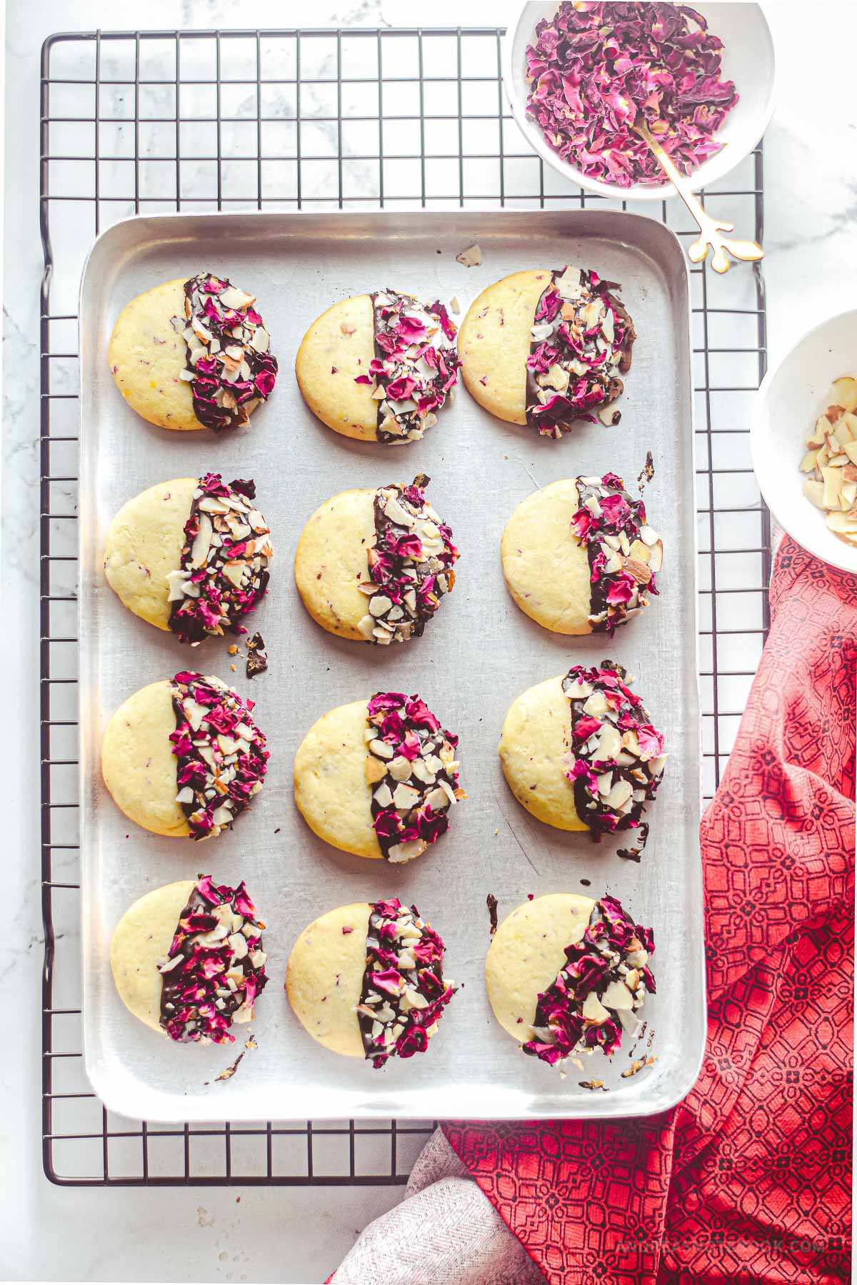 Baking sheet tray on a cooling rack full of rose petal shortbread cookies.