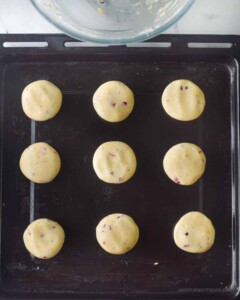Balls of rose shortbread dough on baking sheet.